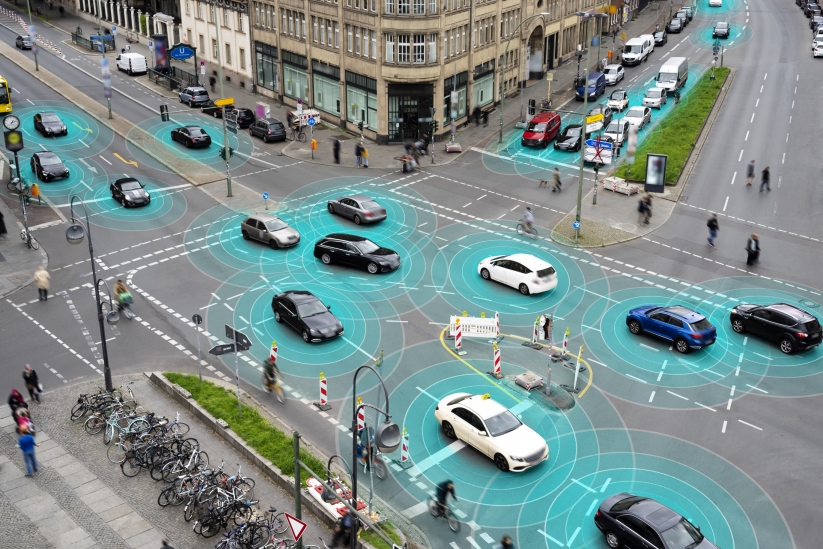 A street scenario where sensor-enhanced automotives are delivering information to each other through a communication infrastructure.